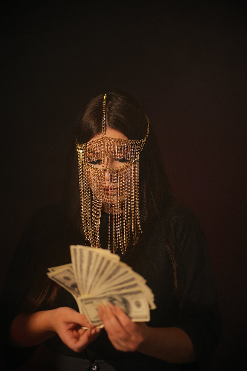 woman wearing face chains holding money